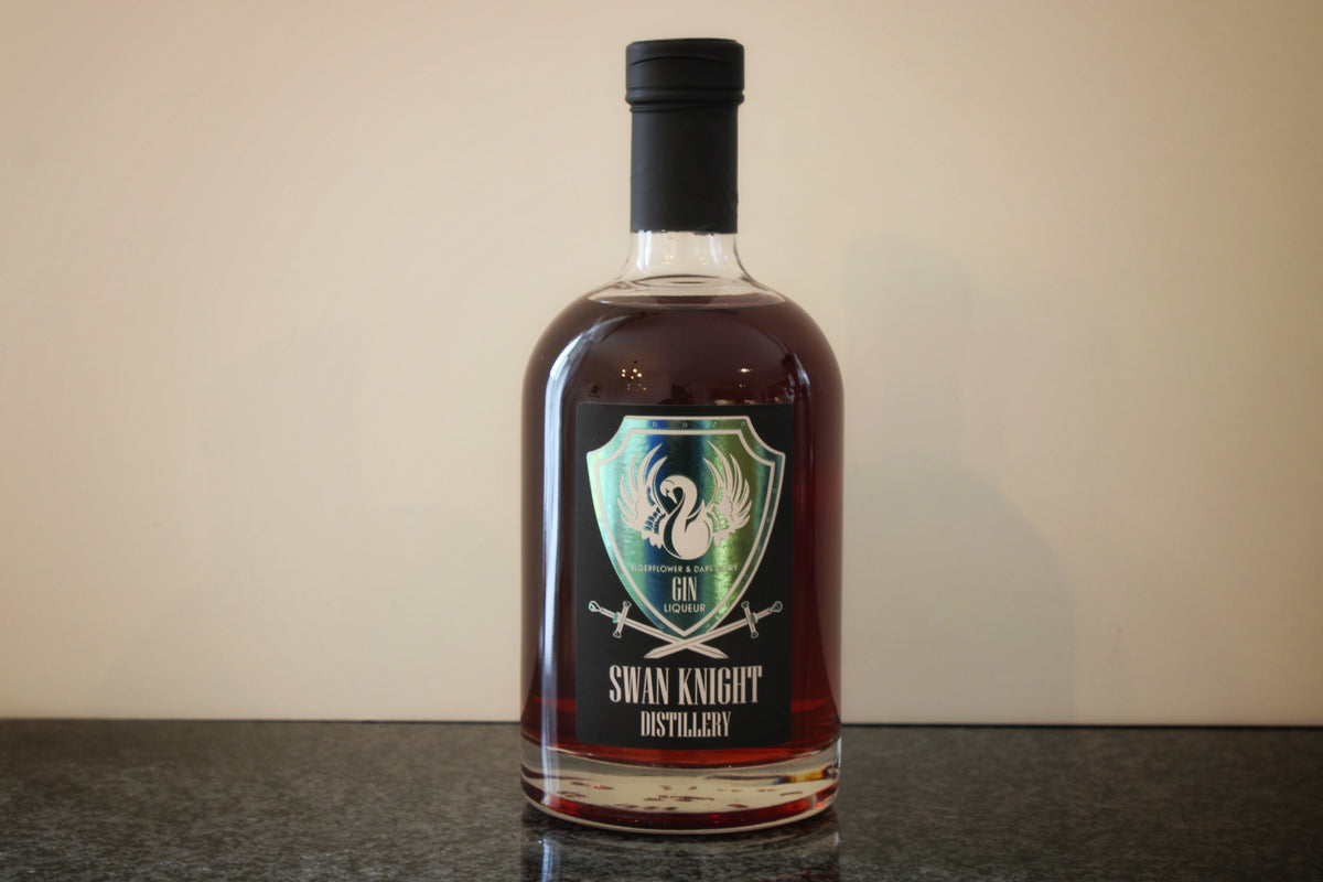 A bottle of Swan Knight Distillery Elderflower and Dark Berry Gin Liqueur on a dark countertop.
