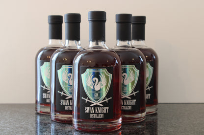 6 bottles of Swan Knight Distillery Elderflower and Dark Berry Gin Liqueur on a dark countertop.